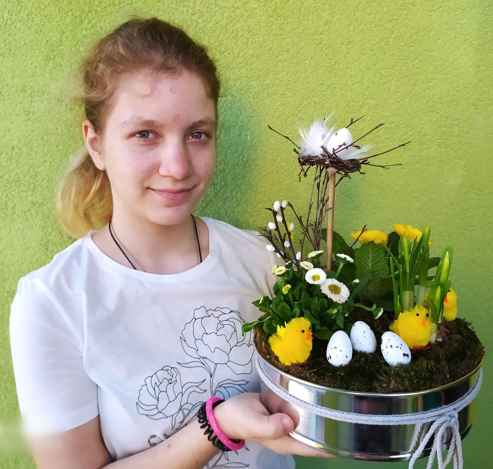 wychowanka prezentuje kompozycję wiosennych roślin w blaszce do pieczenia