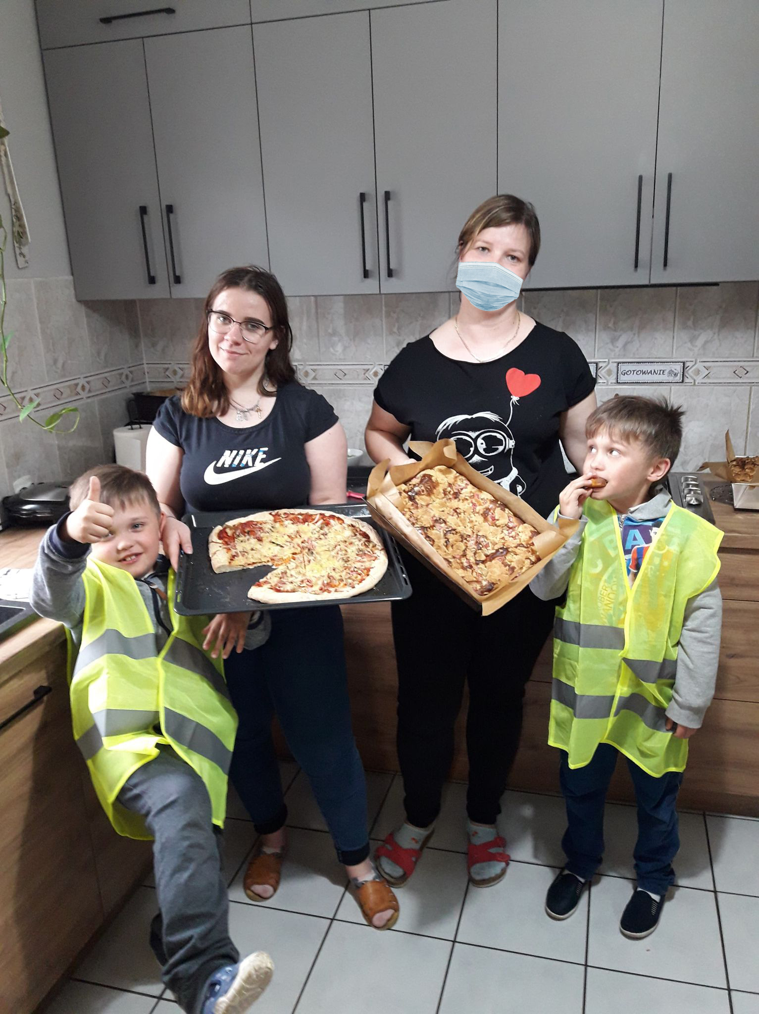 dzieci prezentują pizze w kuchni