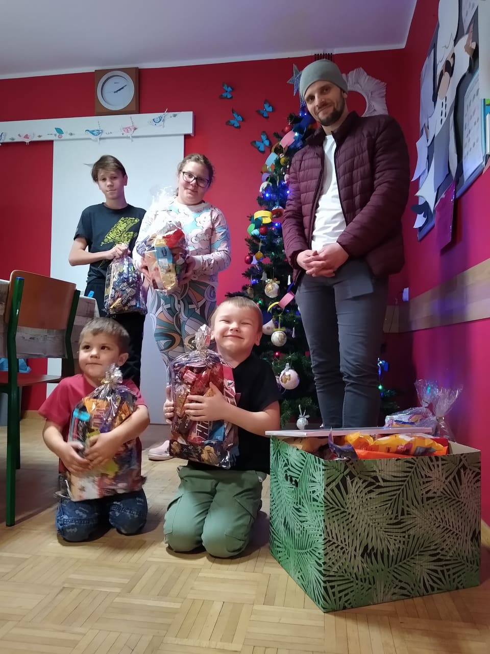 Pan Bartosz z dziećmi przy choince z prezentami