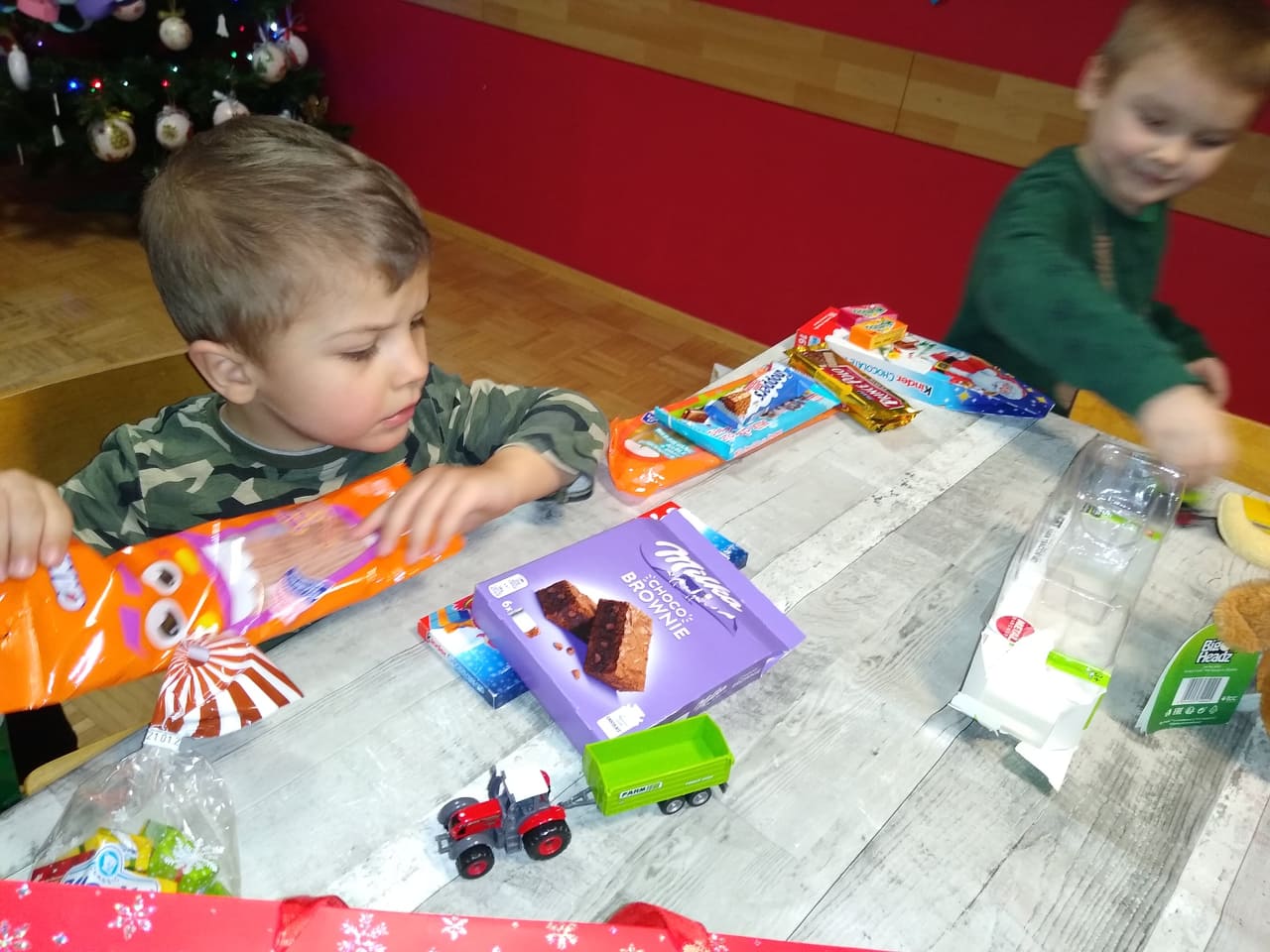 chłopcy bawią się na stole zabawkami z paczek