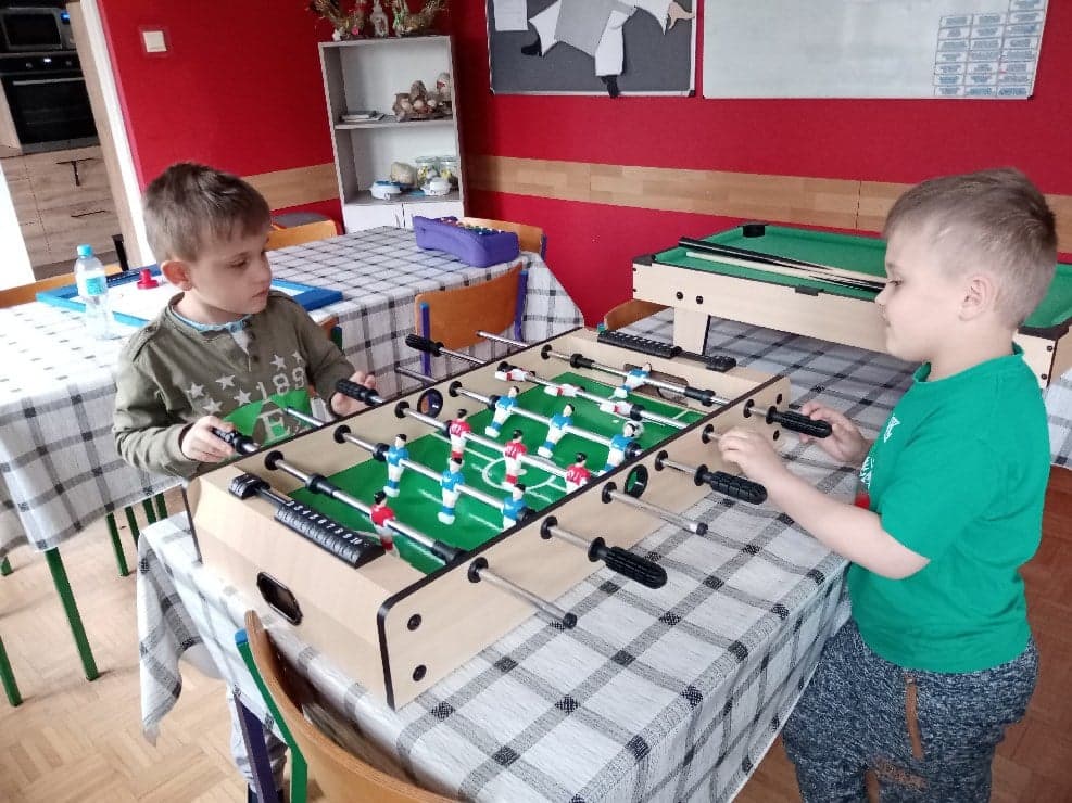 dwaj wychowankowie grają w piłkarzyki stołowe
